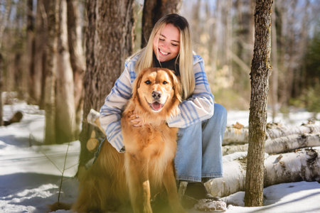 Portrait of a young woman outside on spring season with retriever dogの写真素材