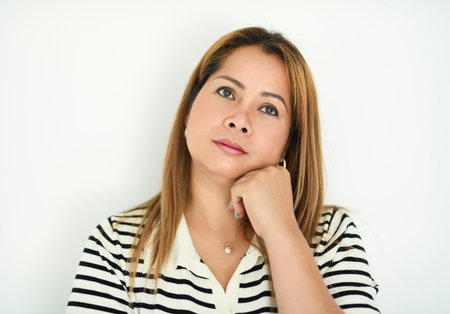 Portrait of asian thai woman standing against studio background
