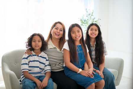 family kid having great time on sofa with his motherの写真素材