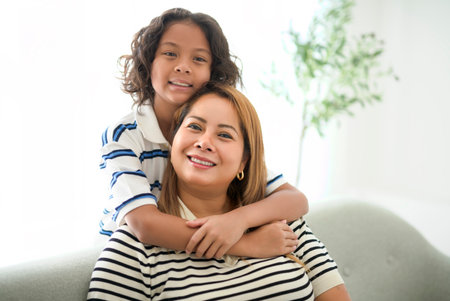 9 years thailand boy having great time on sofa with his mother