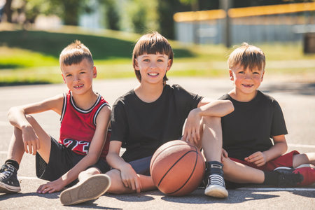 Three brother in sportswear playing basketball game outsideの写真素材