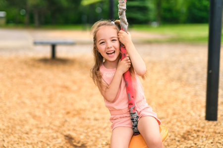 Happy 5 years old girl on a playgroundの写真素材