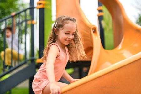 Happy kid slide on playground on summer seasonの写真素材