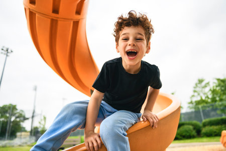 Happy kid slide on playground on summer seasonの写真素材