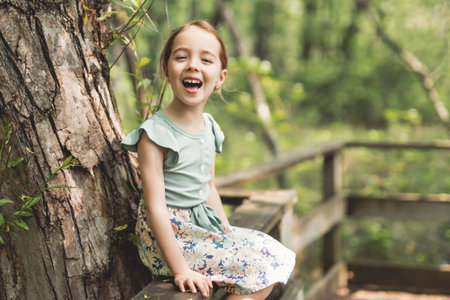Funny smiling child girl 4-5 year old in park on summer seasonの写真素材