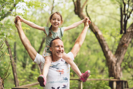 Cute young daughter with her father on countrysideの写真素材
