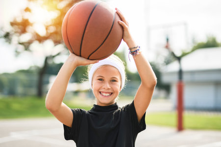 girl child in sportswear playing basketball gameの写真素材