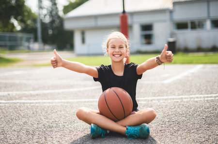 girl child in sportswear playing basketball gameの写真素材
