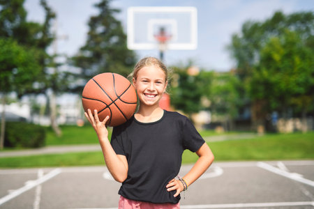 girl child in sportswear playing basketball game