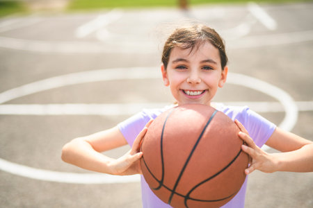 girl child in sportswear playing basketball gameの写真素材