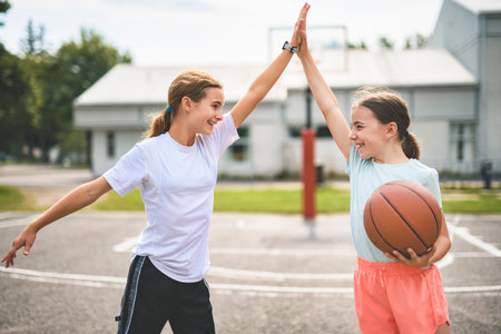 two childs girls in sportswear playing basketball gameの写真素材