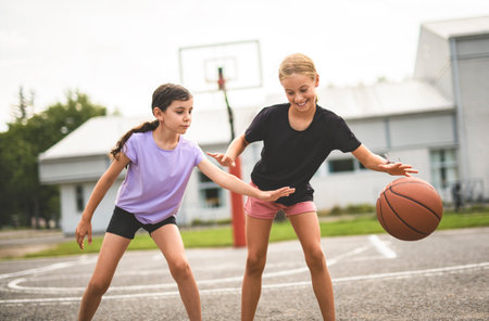 two childs girls in sportswear playing basketball gameの写真素材