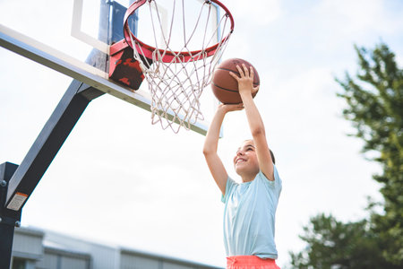 girl child in sportswear playing basketball gameの写真素材