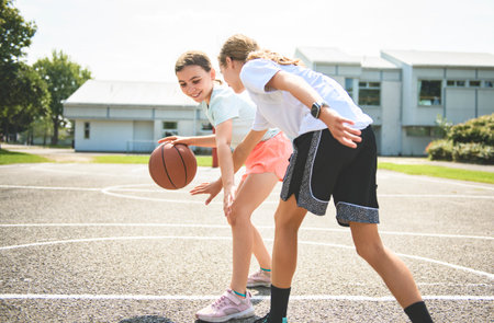 two childs girls in sportswear playing basketball gameの写真素材