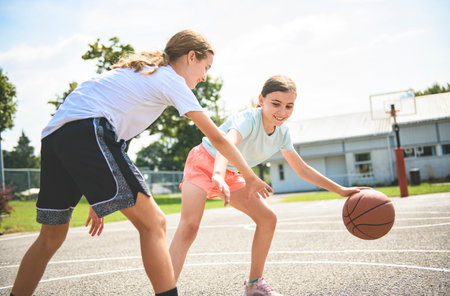 two children girls in sportswear playing basketball gameの写真素材