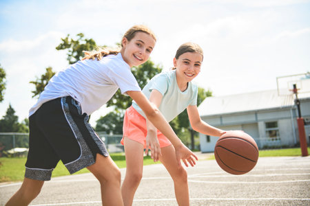 two childs girls in sportswear playing basketball gameの写真素材