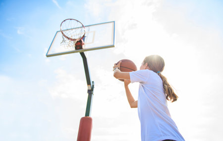 girl child in sportswear playing basketball gameの写真素材