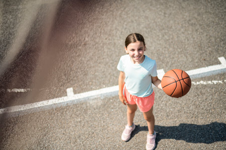 girl child in sportswear playing basketball gameの写真素材