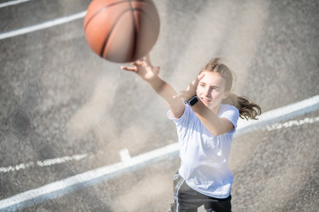 girl child in sportswear playing basketball gameの写真素材
