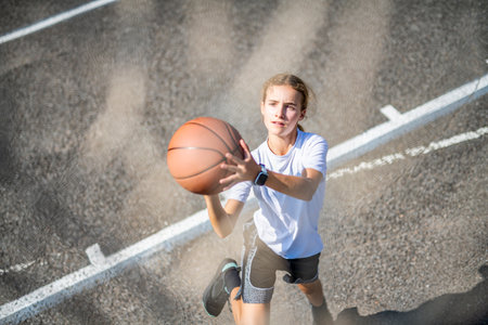 girl child in sportswear playing basketball gameの写真素材