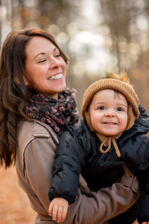 Joyful mother and her little baby. mother and child have fun, laugh and enjoy nature outdoors at autumn park.の写真素材