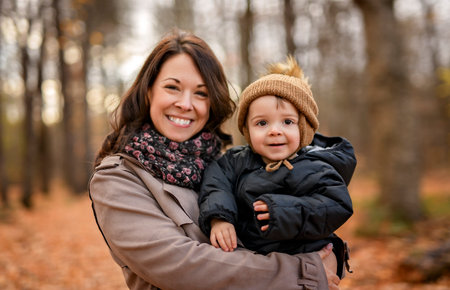Joyful mother and his little baby. mother and child have fun, laugh and enjoy nature outdoors at autumn park.の写真素材