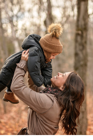 Joyful mother and his little baby. mother and child have fun, laugh and enjoy nature outdoors at autumn park.の写真素材
