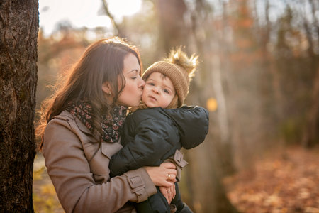 Joyful mother and her little baby. mother and child have fun, laugh and enjoy nature outdoors at autumn park.の写真素材