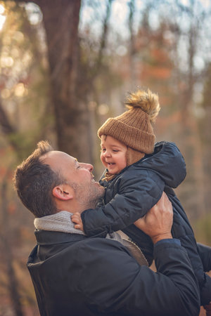 Joyful dad and his little baby. daddy and child have fun, laugh and enjoy nature outdoors at autumn...