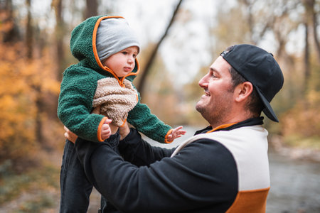 Joyful dad and his little baby. daddy and child have fun, laugh and enjoy nature outdoors at autumn...