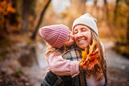 Joyful mom and his little child girl. mother and child have fun outdoors at autumn park.
