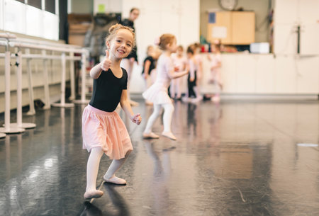 Cute little ballerina having fun on ballet roomの写真素材