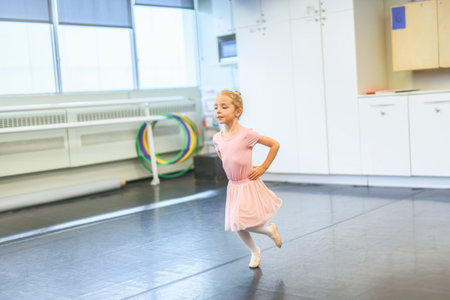 Cute little ballerina having fun on ballet roomの写真素材