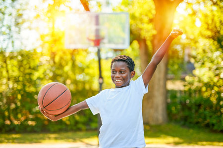 portrait of a boy kid playing with a basketball in parkの写真素材