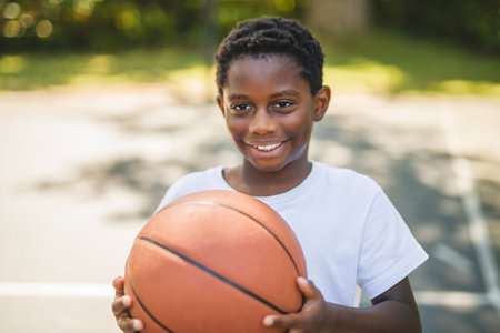 portrait of a boy playing with a basketball in parkの写真素材