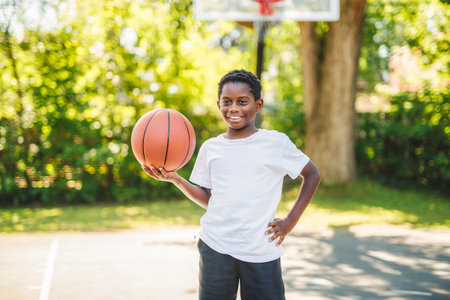 portrait of a boy kid playing with a basketball in parkの写真素材