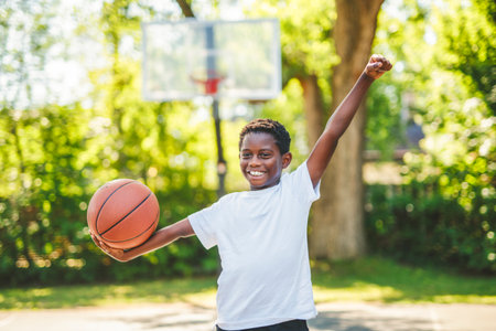 portrait of a boy kid playing with a basketball in parkの写真素材