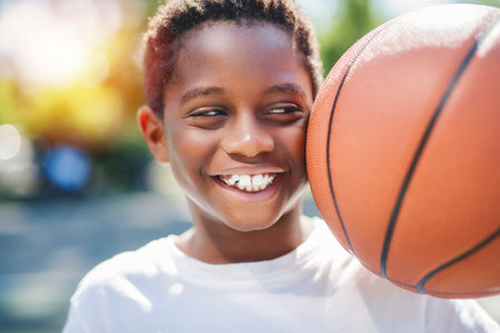 portrait of a boy kid playing with a basketball in parkの写真素材