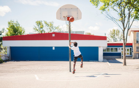 portrait of a boy kid playing with a basketball in park