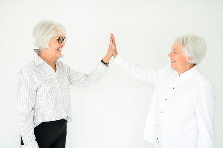 Portrait of two elderly woman over grey background.の写真素材