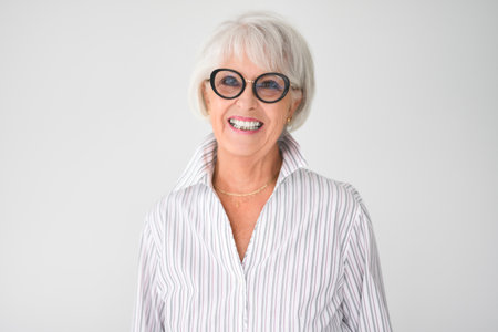 Portrait of elderly woman in eyeglasses over grey background.の写真素材