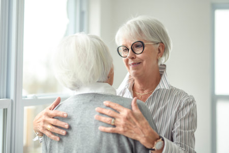 Portrait of two elderly woman over grey background hug togetherの写真素材