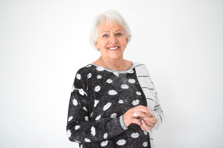 Portrait of elderly woman over grey background.