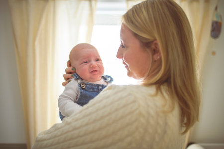 Cute small 1 month baby boy at home. Mother with little newborn infant.の写真素材