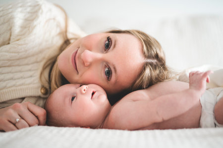 Cute small 1 month baby boy at home. Mother with little newborn infant.