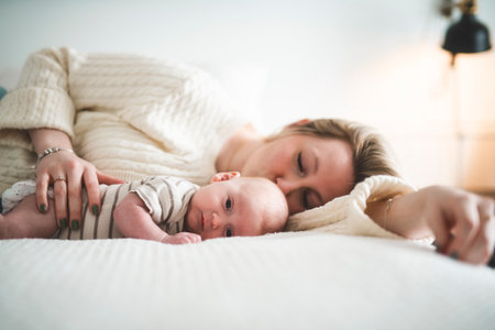 Cute small 1 month baby boy at home. Mother with little newborn infant.の写真素材