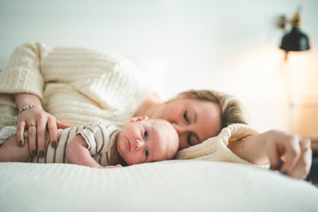 Cute small 1 month baby boy at home. Mother with little newborn infant.の写真素材