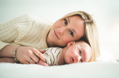 Cute small 1 month baby boy at home. Mother with little newborn infant.の写真素材