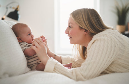 Cute small 1 month baby boy at home. Mother with little newborn infant.の写真素材