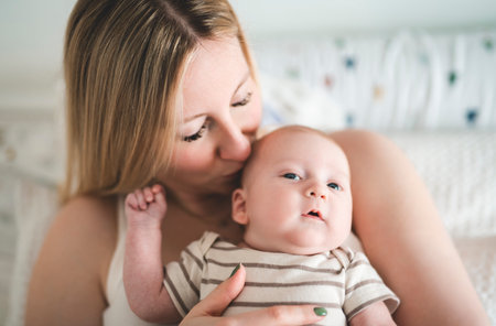 Cute small 1 month baby boy at home. Mother with little newborn infant.の写真素材